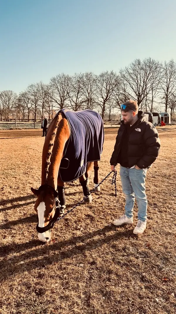 Sean Fischer on a farm near Hamburg, holding a horse on a lead